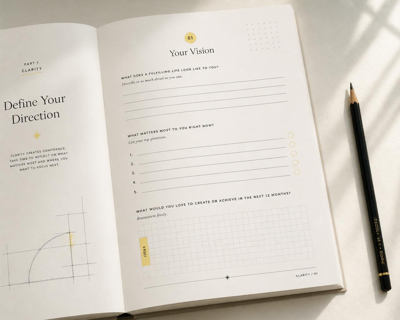 An open interior spread of the workbook showing guided vision prompts, planning lines, and subtle blueprint grid details